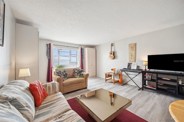 living room with a textured ceiling and light wood-type flooring