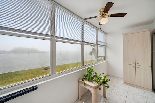 unfurnished sunroom with a water view, ceiling fan, and plenty of natural light