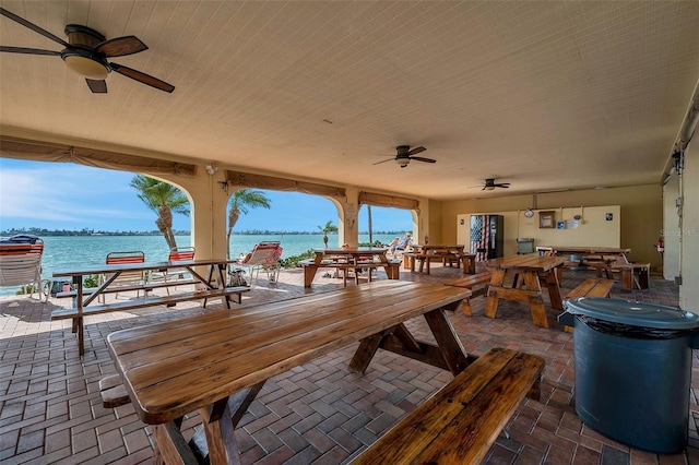 view of patio / terrace with ceiling fan and a water view