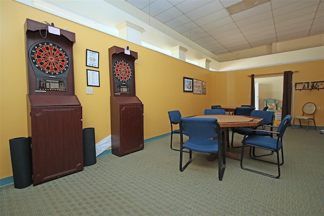 carpeted dining area with a drop ceiling