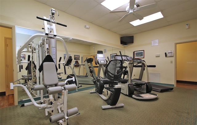 workout area with carpet floors, a paneled ceiling, and ceiling fan