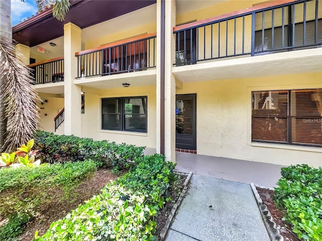 doorway to property featuring stucco siding