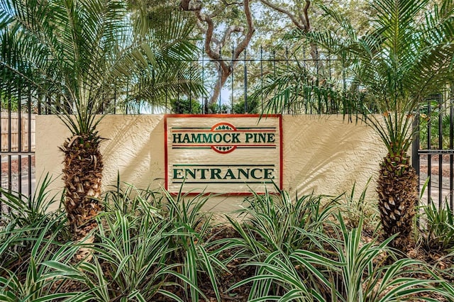 community / neighborhood sign featuring fence