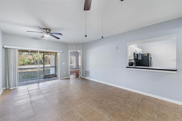 unfurnished living room featuring ceiling fan and light tile patterned floors