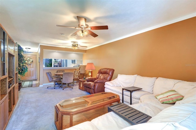 living room with ceiling fan, ornamental molding, and light carpet