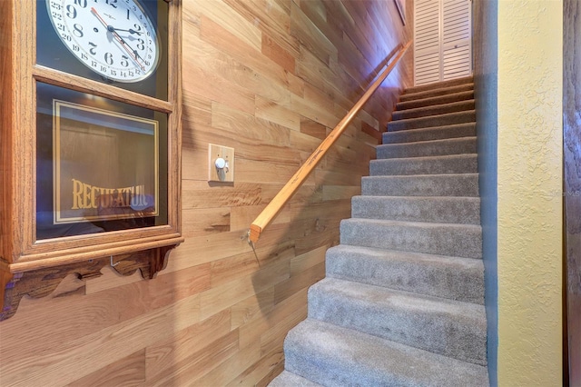 stairs featuring wood walls