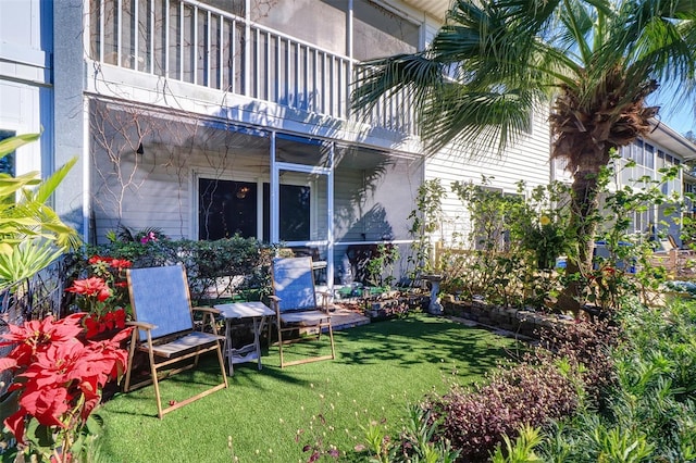 back of property featuring a lawn and a balcony