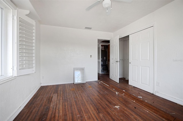 unfurnished bedroom featuring dark wood-style floors, baseboards, and visible vents