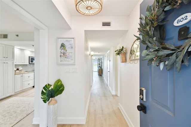 hallway with light hardwood / wood-style flooring