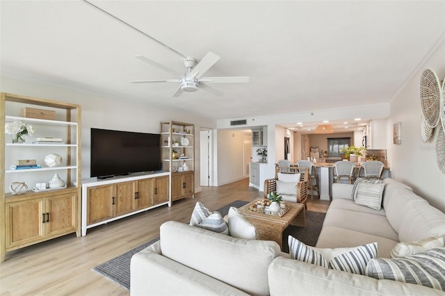 living room featuring light hardwood / wood-style flooring and ceiling fan