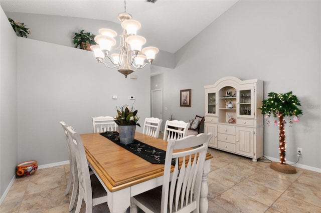 dining room featuring an inviting chandelier and high vaulted ceiling