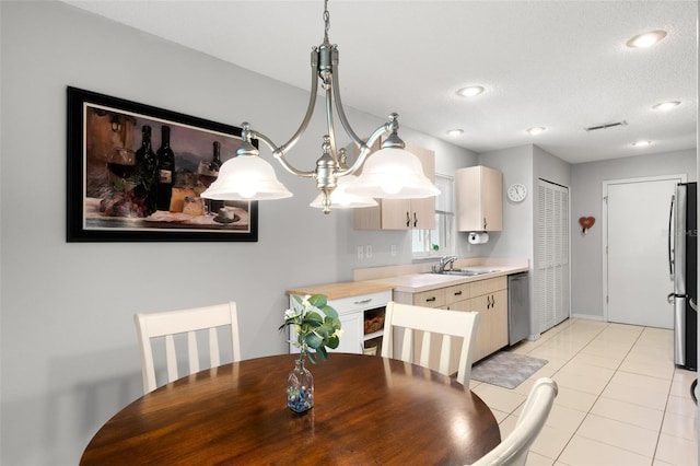 dining room featuring sink, a textured ceiling, and light tile patterned floors