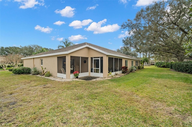 back of house with a sunroom and a lawn