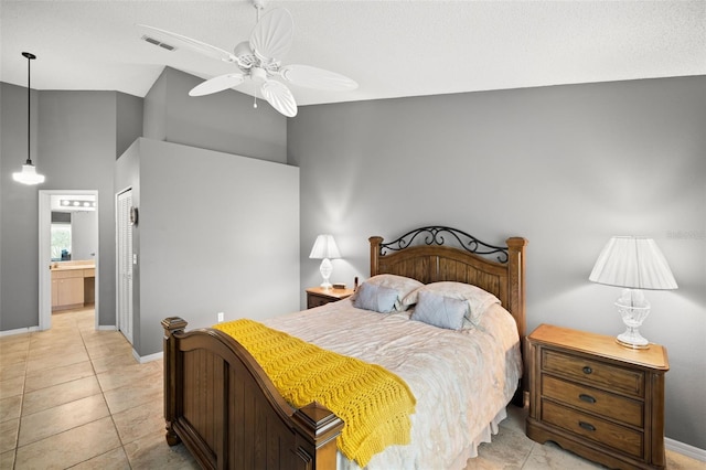 bedroom with ensuite bathroom, light tile patterned floors, ceiling fan, and a closet