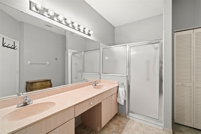 bathroom with vanity, an enclosed shower, and a textured ceiling