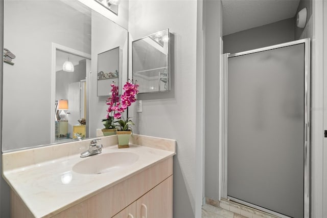 bathroom with vanity, an enclosed shower, and a textured ceiling