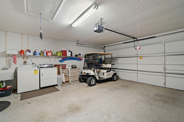 garage featuring sink, a garage door opener, and washing machine and clothes dryer