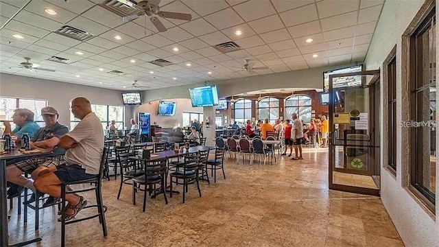 dining space with a paneled ceiling and ceiling fan