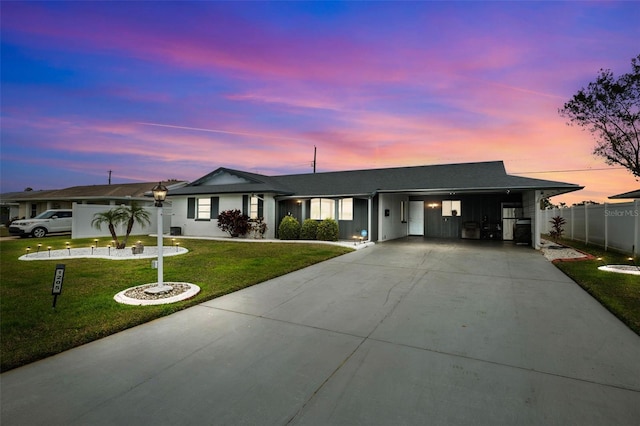 ranch-style house featuring a yard and a carport