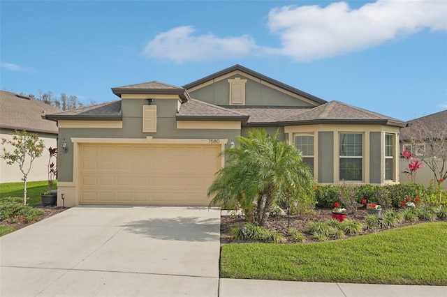 view of front facade with driveway, a front yard, a garage, and stucco siding