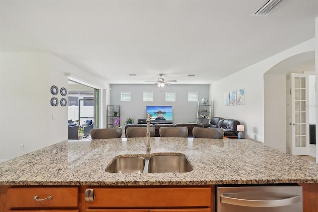 7580 Pool Compass Loop, Wesley Chapel, FL 33545 - kitchen featuring stainless steel dishwasher, brown cabinets, open floor plan, and ceiling fan
