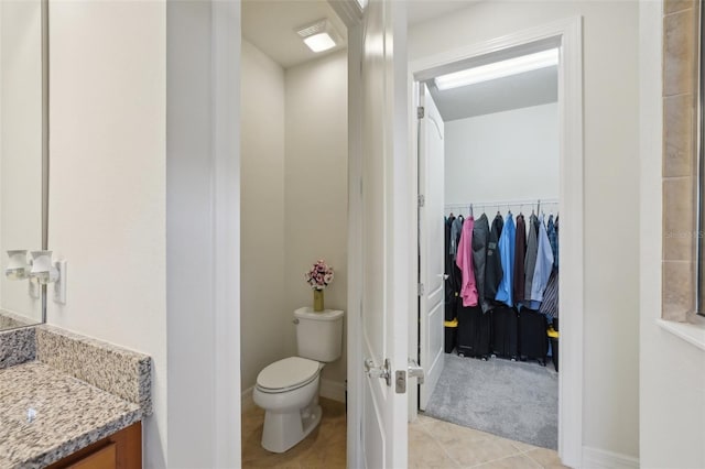 7580 Pool Compass Loop, Wesley Chapel, FL 33545 - bathroom with vanity, baseboards, tile patterned floors, toilet, and a spacious closet
