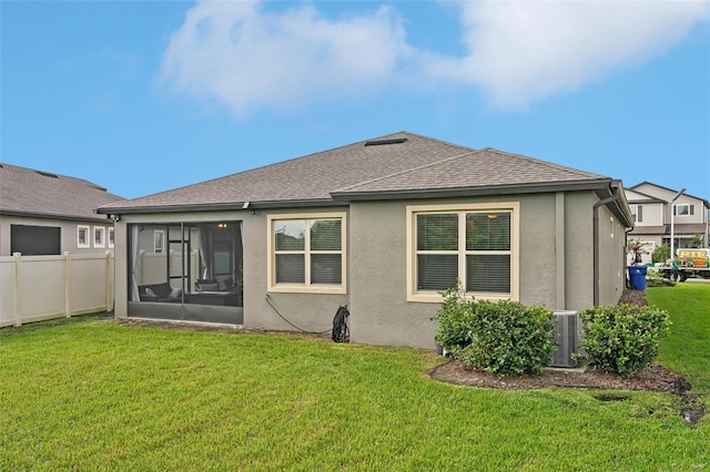 7580 Pool Compass Loop, Wesley Chapel, FL 33545 - rear view of house with fence, a shingled roof, stucco siding, a sunroom, and a yard