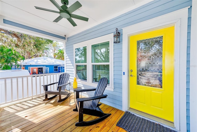 wooden terrace with ceiling fan and covered porch