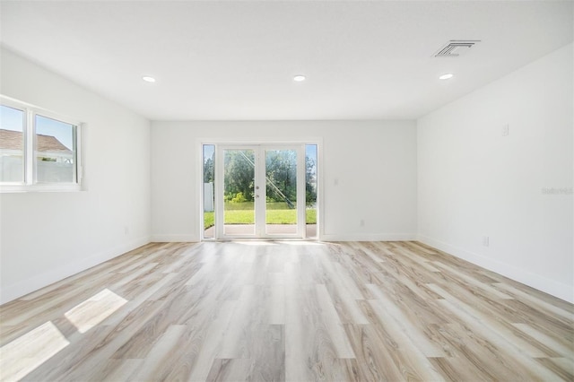 unfurnished room with french doors and light hardwood / wood-style flooring