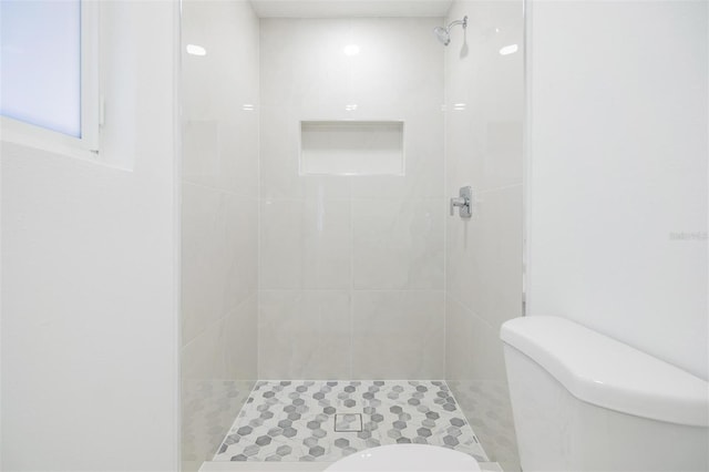 bathroom featuring toilet and tiled shower