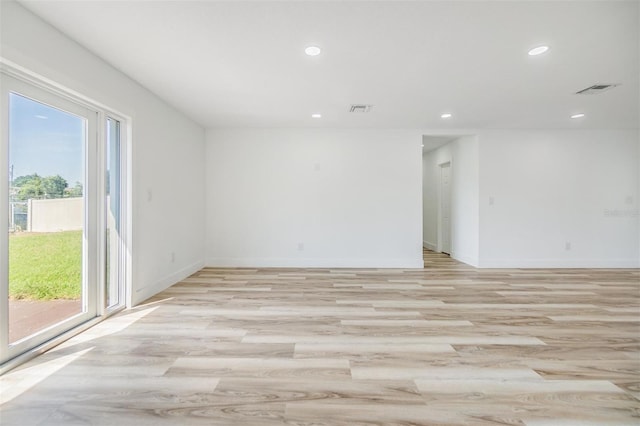 spare room with a healthy amount of sunlight and light hardwood / wood-style flooring