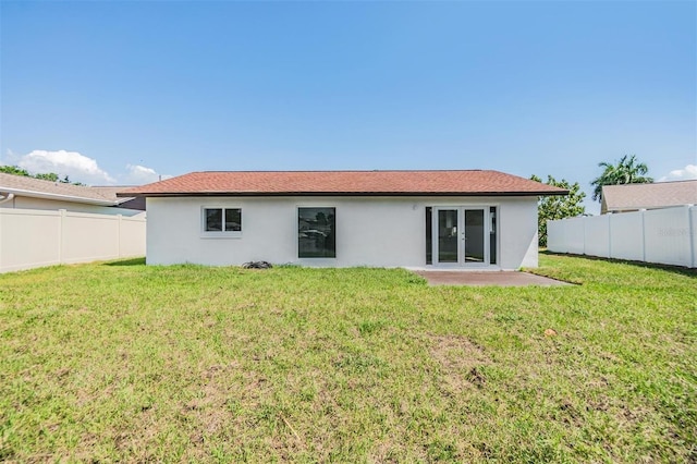 rear view of house with a patio area and a lawn