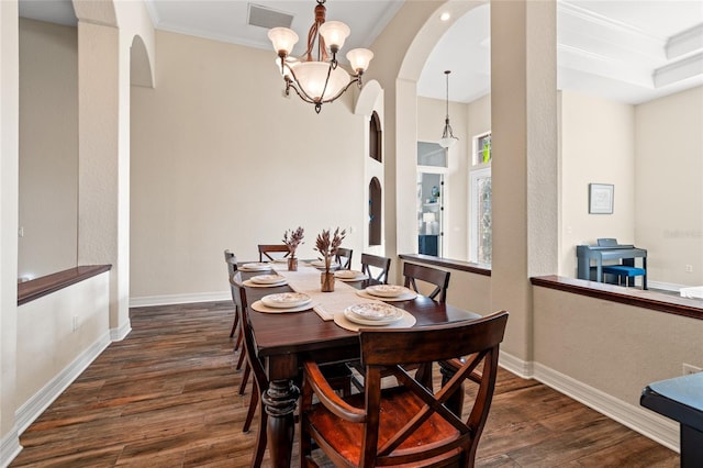 dining area with ornamental molding, a chandelier, and dark hardwood / wood-style flooring