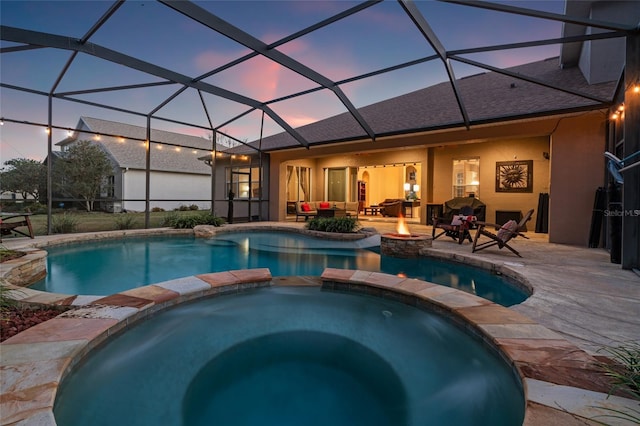 pool at dusk featuring an in ground hot tub, a lanai, a patio, and an outdoor fire pit