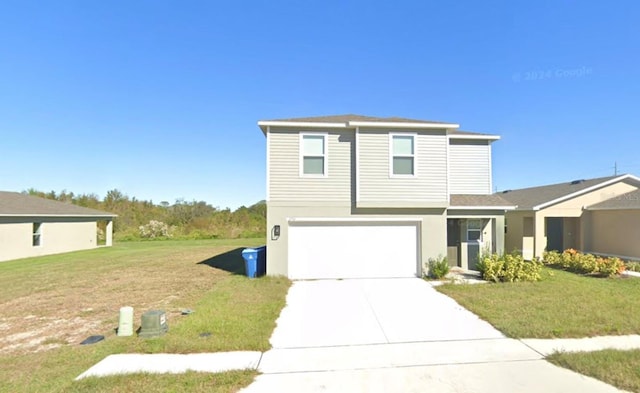 view of front of house featuring a front yard, driveway, an attached garage, and stucco siding