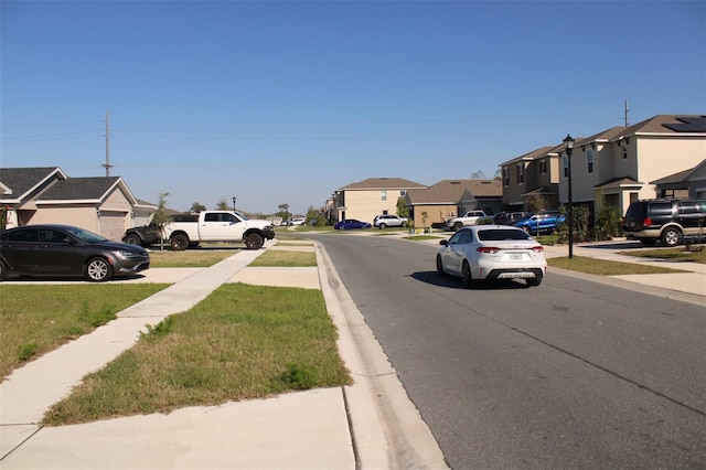 view of street with sidewalks, a residential view, and curbs