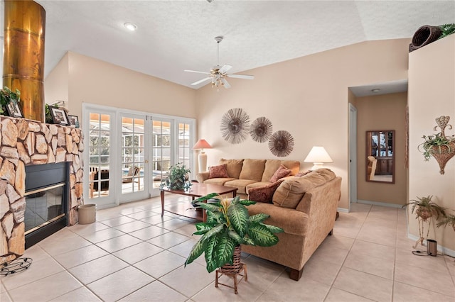 living room featuring vaulted ceiling, a stone fireplace, light tile patterned floors, and a textured ceiling