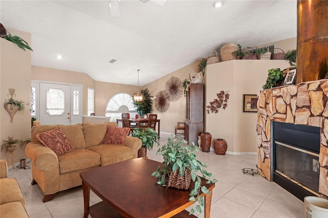 tiled living room with a stone fireplace