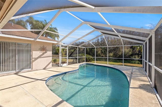 view of pool with a patio area and glass enclosure