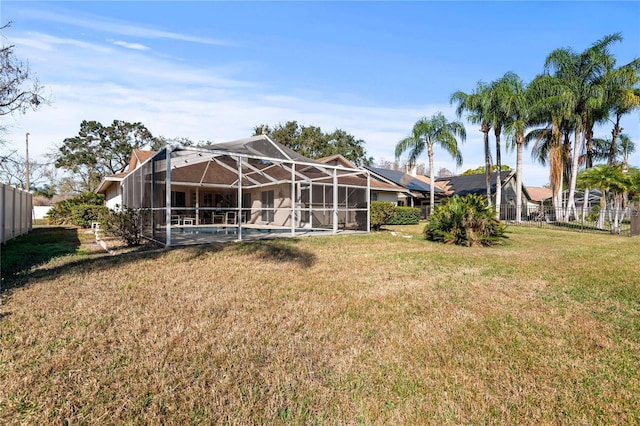 back of property with a fenced in pool, a lanai, and a yard