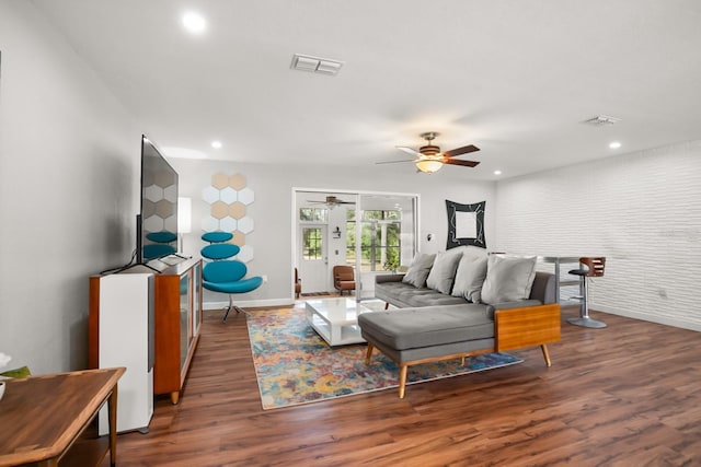 bedroom with ceiling fan, brick wall, and dark hardwood / wood-style floors