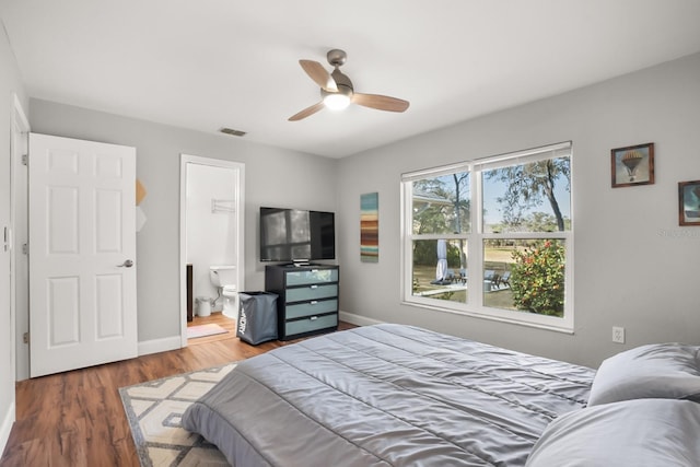 bedroom featuring ceiling fan, connected bathroom, and dark hardwood / wood-style flooring