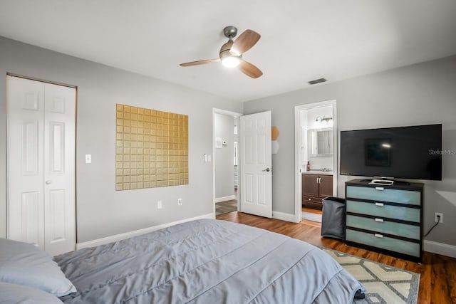 bedroom featuring ceiling fan, ensuite bathroom, hardwood / wood-style floors, and a closet