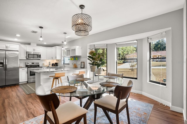 dining area with sink and hardwood / wood-style floors