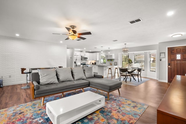 living room featuring wood-type flooring and ceiling fan