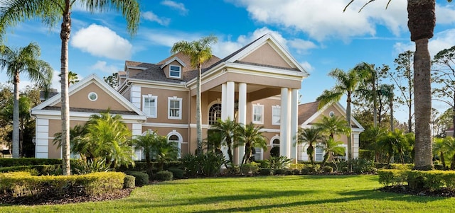 neoclassical home featuring a front lawn and stucco siding