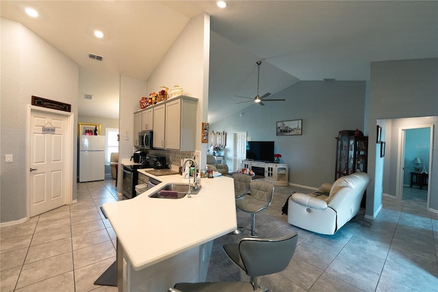 kitchen with sink, light tile patterned floors, range with electric stovetop, gray cabinets, and white fridge