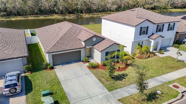 view of front of property with stucco siding, a water view, driveway, and roof with shingles