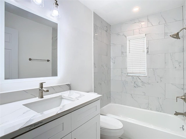 full bathroom with vanity, tiled shower / bath combo, and toilet