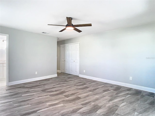 unfurnished bedroom with connected bathroom, ceiling fan, and a closet